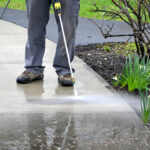 man cleans path. Pearson uses power washer, spring cleaning.